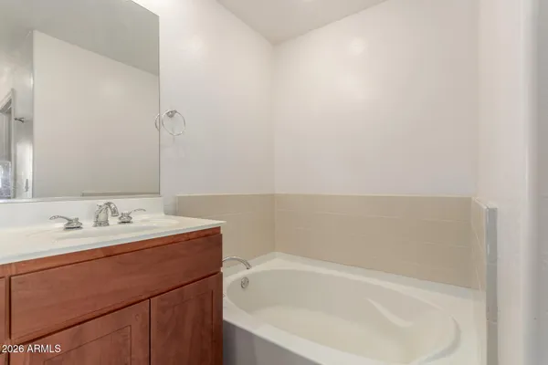 a bathroom with a bathtub sink and mirror