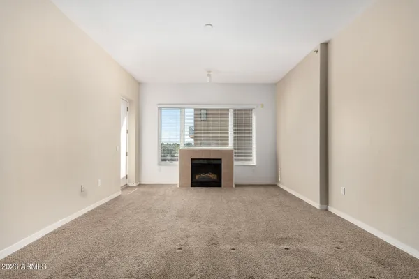 an empty room with windows and fireplace