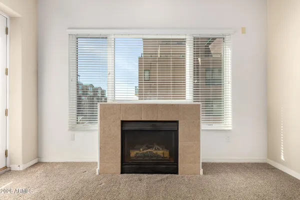 a living room with a fireplace and a large window