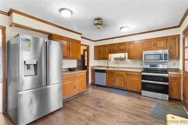 a kitchen with stainless steel appliances a refrigerator sink and microwave