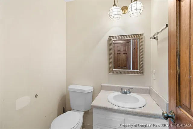 a bathroom with a granite countertop toilet and a sink