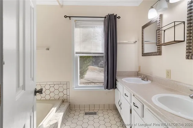a bathroom with a granite countertop sink a mirror and a bathtub