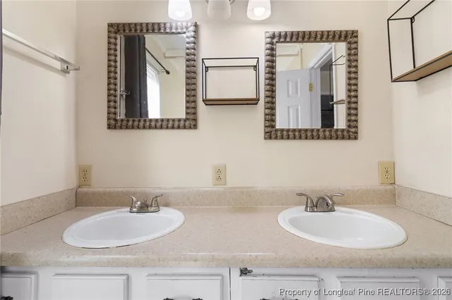 a bathroom with double vanity sinks and a mirror
