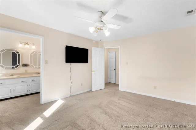 a view of a livingroom with chandelier fan and bathroom