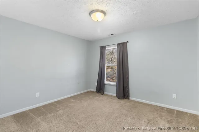 an empty room with a fan and a window