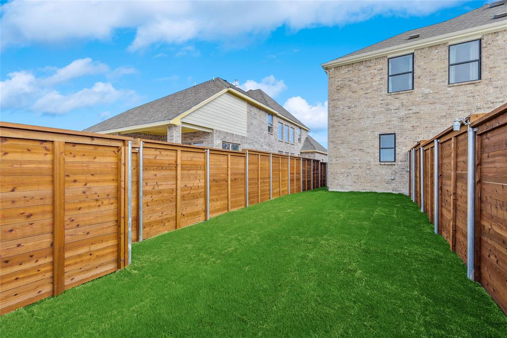 1604 Casting Ridge Mesquite, TX 75181 - Photo 38 of 38 Expansive backyard featuring artificial turf, new wooden privacy fencing, and a brick exterior