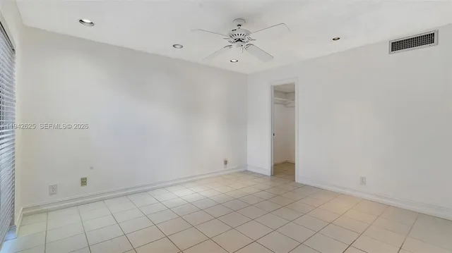 a large white room with a large window and chandelier