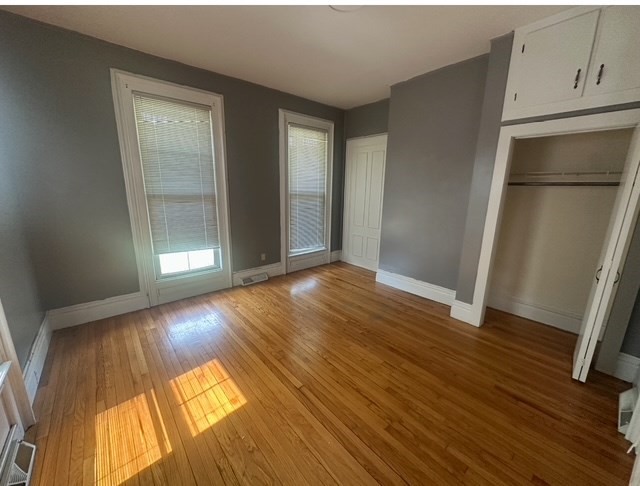 an empty room with wooden floor and closet