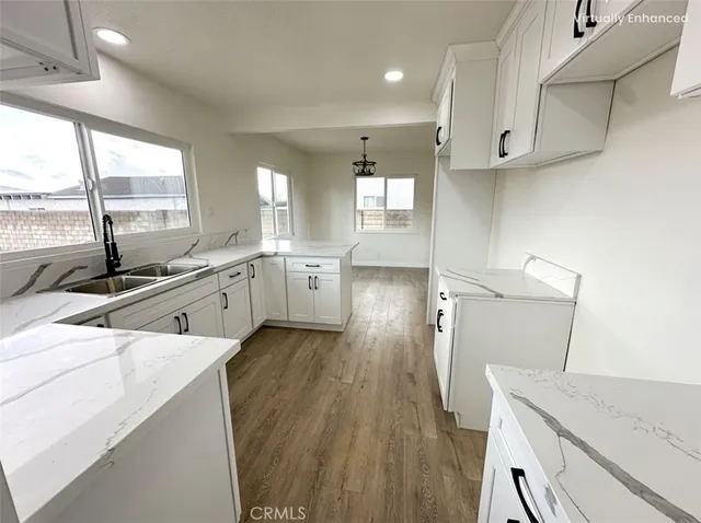 a view of a kitchen with a sink wooden cabinets and a window