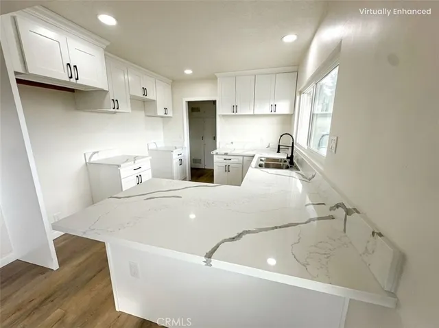 a kitchen with stainless steel appliances a sink a stove a refrigerator cabinets and a dining table