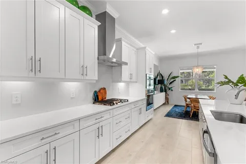 a kitchen with stainless steel appliances kitchen island a chandelier and a view of living room