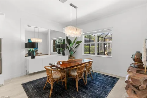 a dining room filled chandelier and kitchen view
