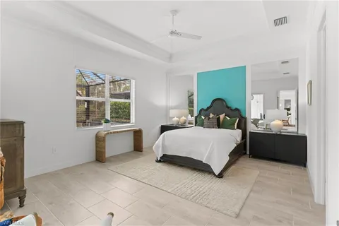 a bedroom with a bed flat screen tv and windows
