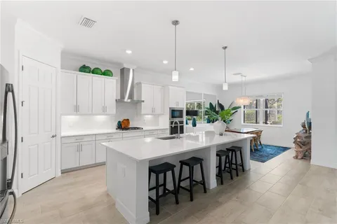 a kitchen with kitchen island a stove a table and chairs in it