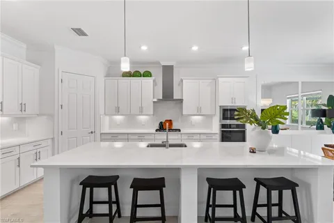a kitchen with stainless steel appliances white cabinets and a stove top oven