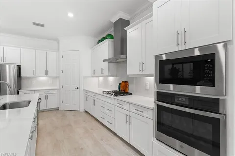 a kitchen with white cabinets and sink