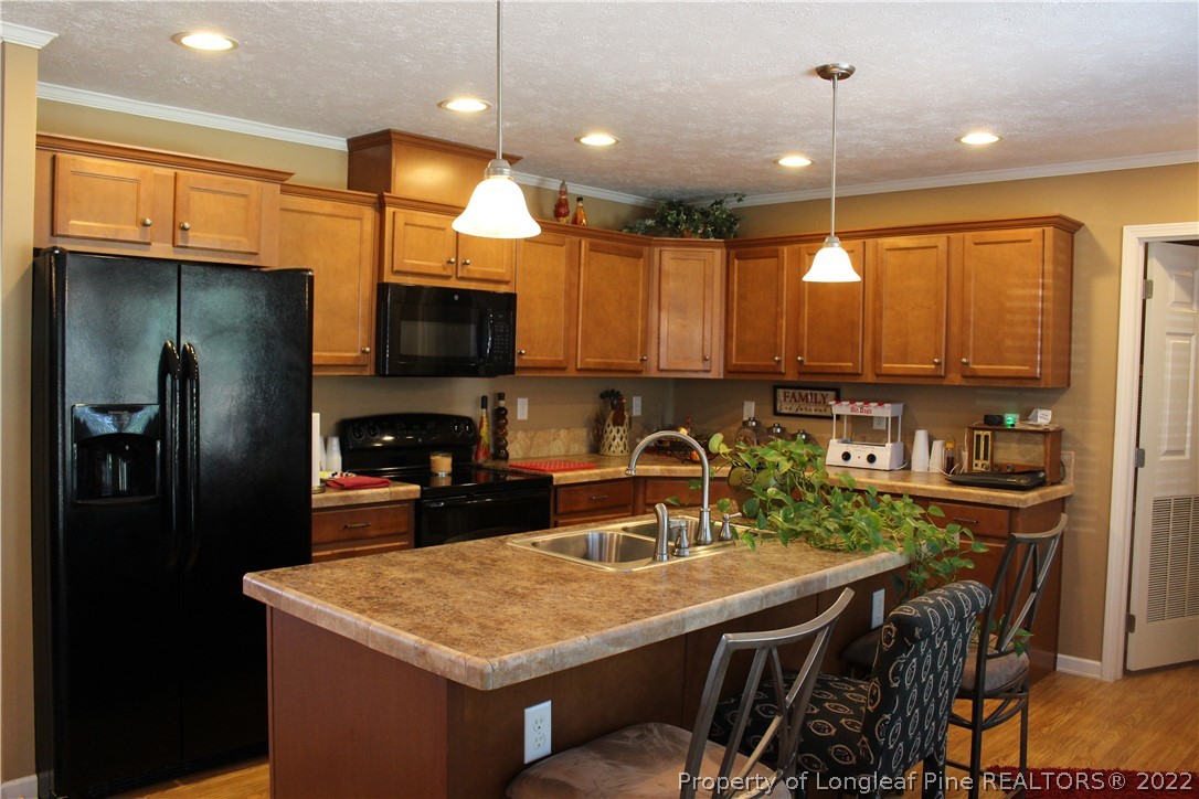 4023 Hoffman Road Jackson Springs, NC 27281 - Photo 8 of 22 a kitchen with a table chairs refrigerator and microwave