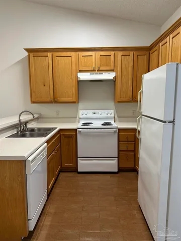 a kitchen with a refrigerator sink stove and cabinets