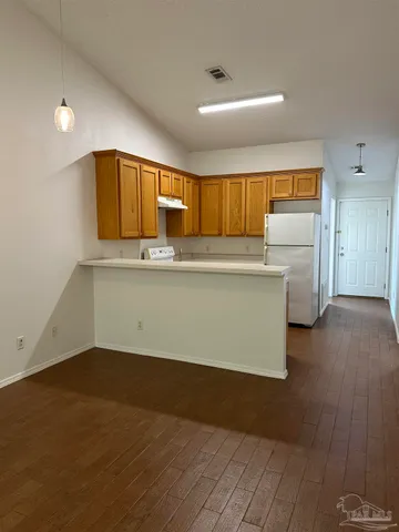 a kitchen with cabinets and wooden floor