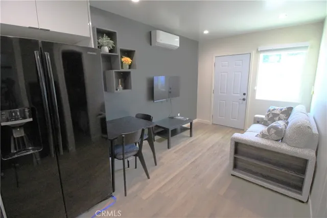 a living room with furniture and a refrigerator