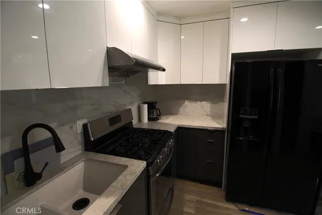 a kitchen with a sink a refrigerator and cabinets