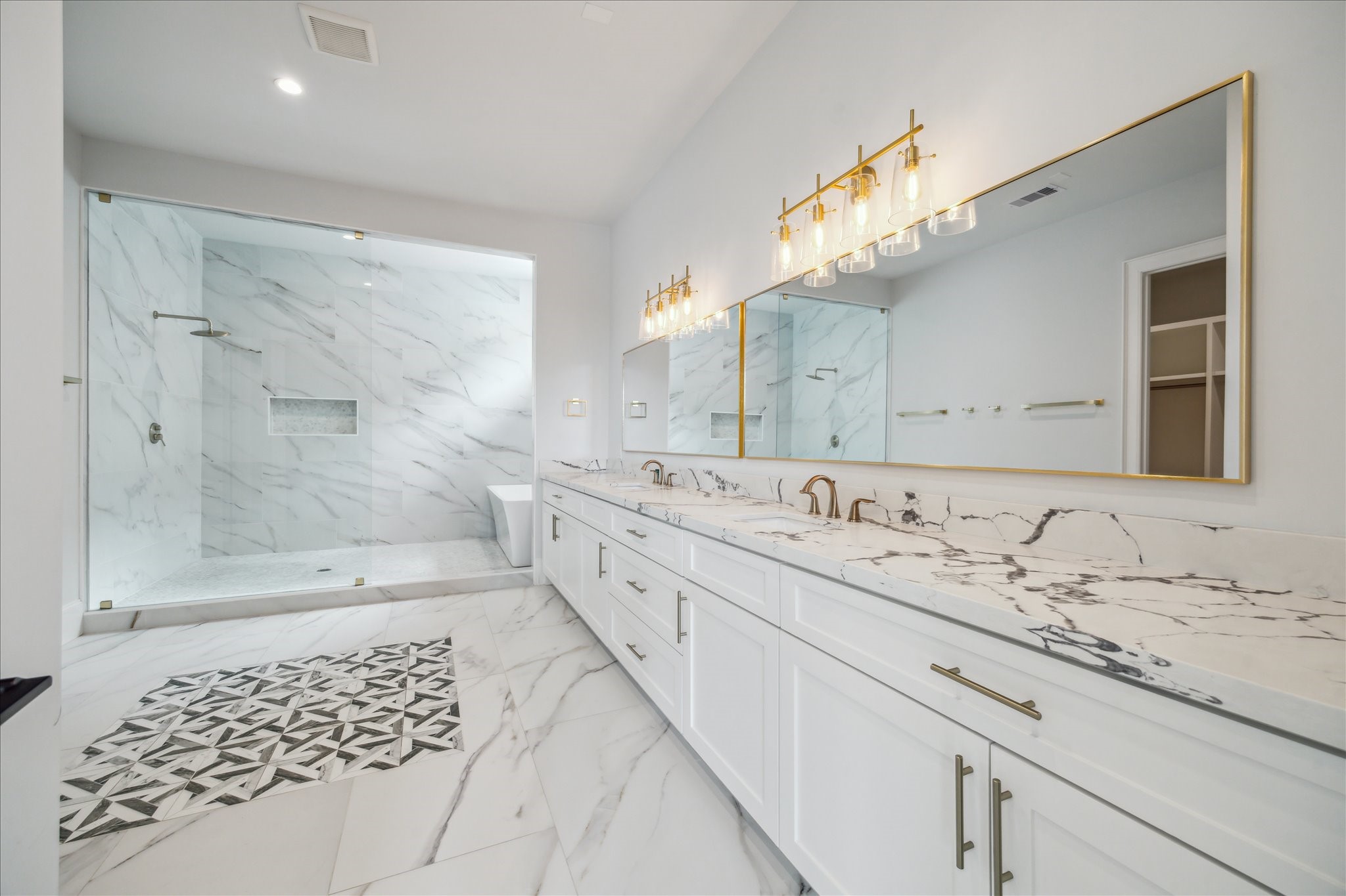 2202 Hewitt Drive Houston, TX 77018 - Photo 23 of 39 The primary bathroom features an oversized double sink vanity with quartz countertops and extensive soft-close cabinetry and drawers for exceptional storage. Additional highlights include marble tile flooring and a private water closet.