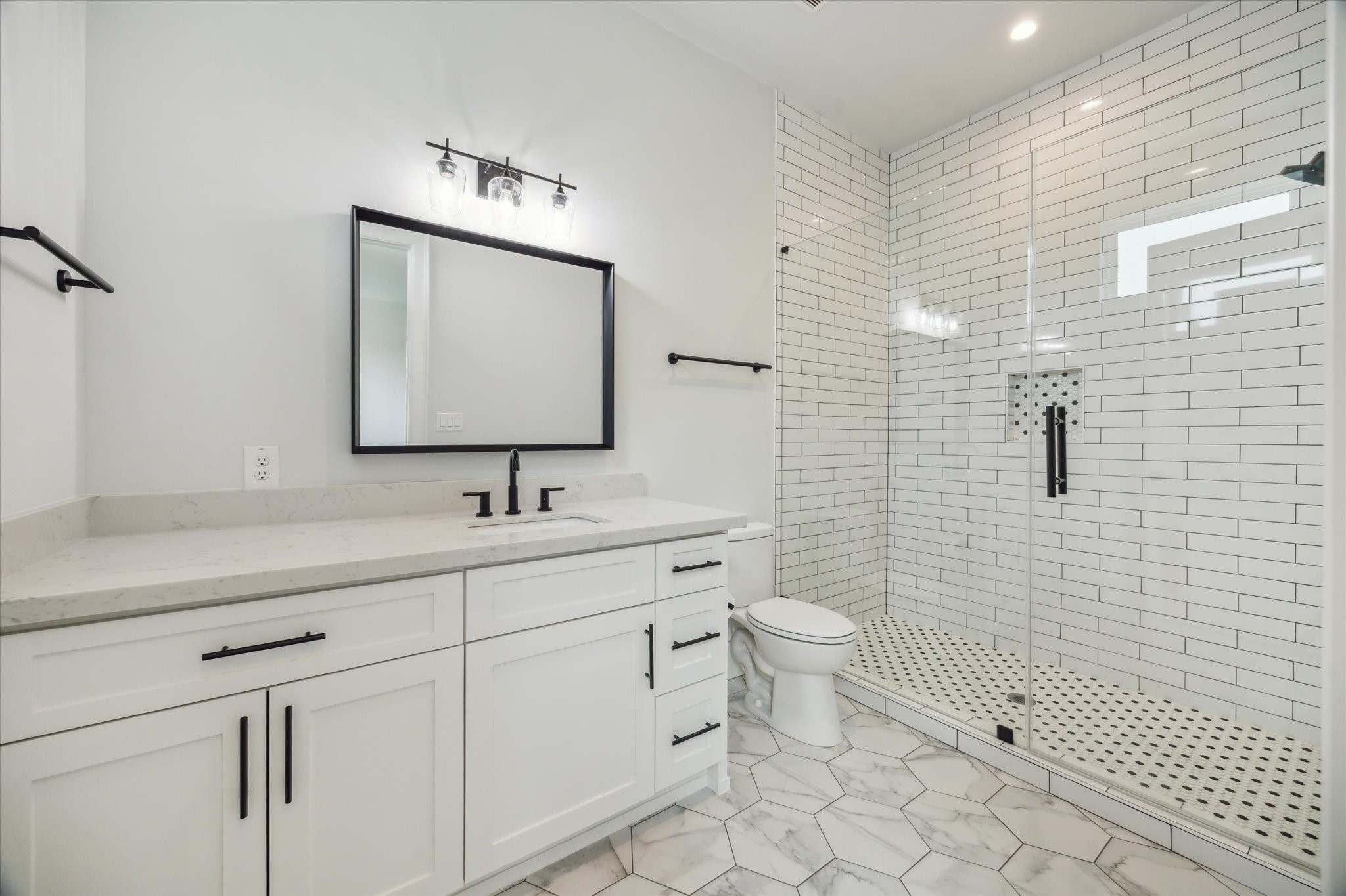 2202 Hewitt Drive Houston, TX 77018 - Photo 32 of 39 Attached bathroom with a large walk-in shower featuring a frameless glass door, stylish tile selections, and quartz countertops.