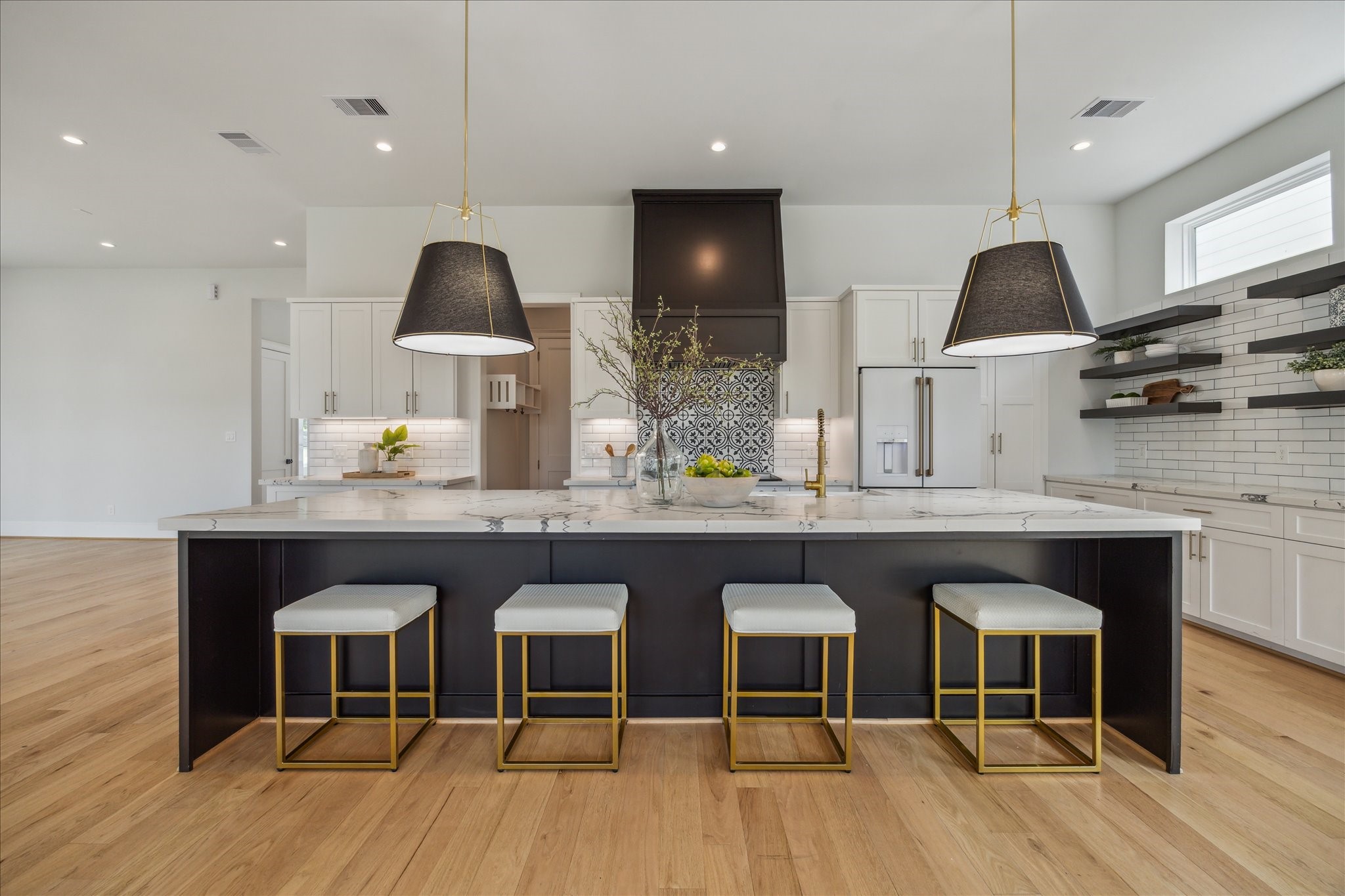 2202 Hewitt Drive Houston, TX 77018 - Photo 10 of 39 A big, bold kitchen featuring a massive island that comfortably seats 4-5, highlighted by striking pendant lighting and a beautiful quartz slab countertop.