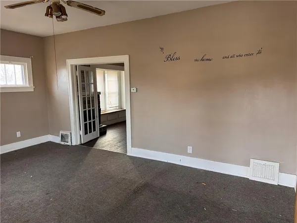 a view of a livingroom with a ceiling fan and window