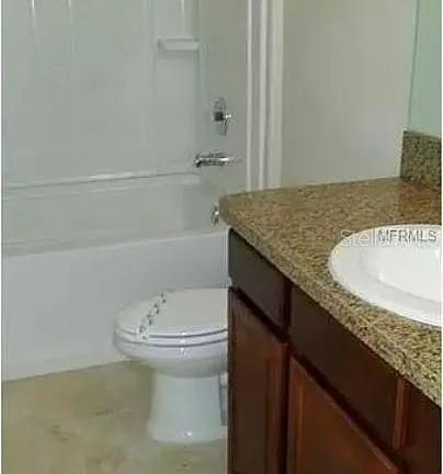 1606 Redmond Brook Lane Ruskin, FL 33570 - Photo 13 of 26 a bathroom with a granite countertop sink a toilet and bathtub