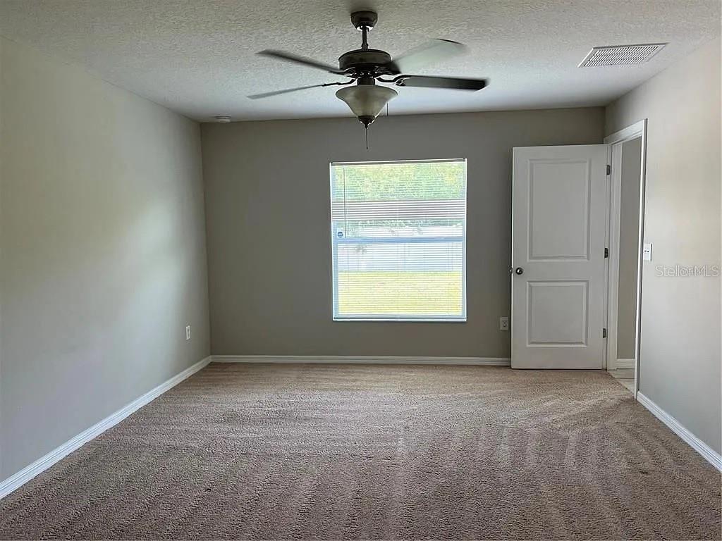 1606 Redmond Brook Lane Ruskin, FL 33570 - Photo 19 of 26 an empty room with a chandelier fan and windows