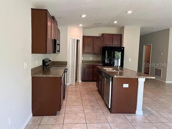 1606 Redmond Brook Lane Ruskin, FL 33570 - Photo 7 of 26 a kitchen with stainless steel appliances granite countertop a stove a sink and a refrigerator