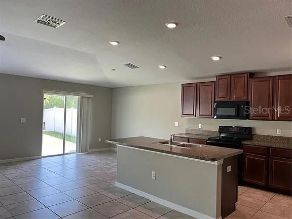 1606 Redmond Brook Lane Ruskin, FL 33570 - Photo 10 of 26 a kitchen with kitchen island granite countertop a sink a stove cabinets and a window