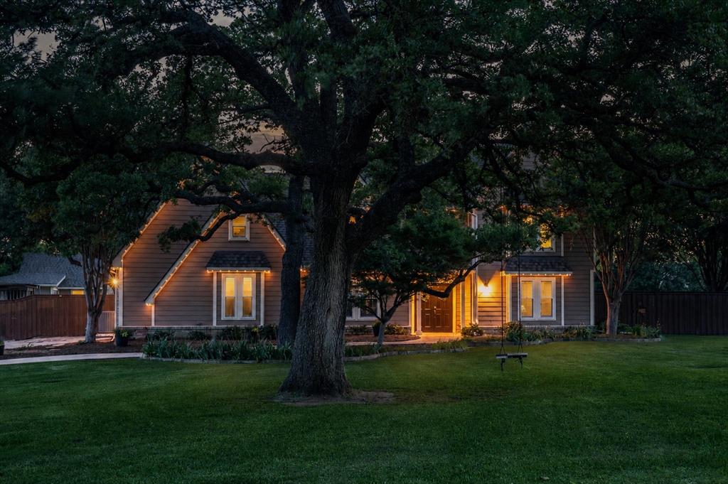 410 Simmons Road Double Oak, TX 75077 - Photo 7 of 40 Stunning twilight shot highlights the charm and curb appeal of this classic home nestled beneath towering mature oaks.