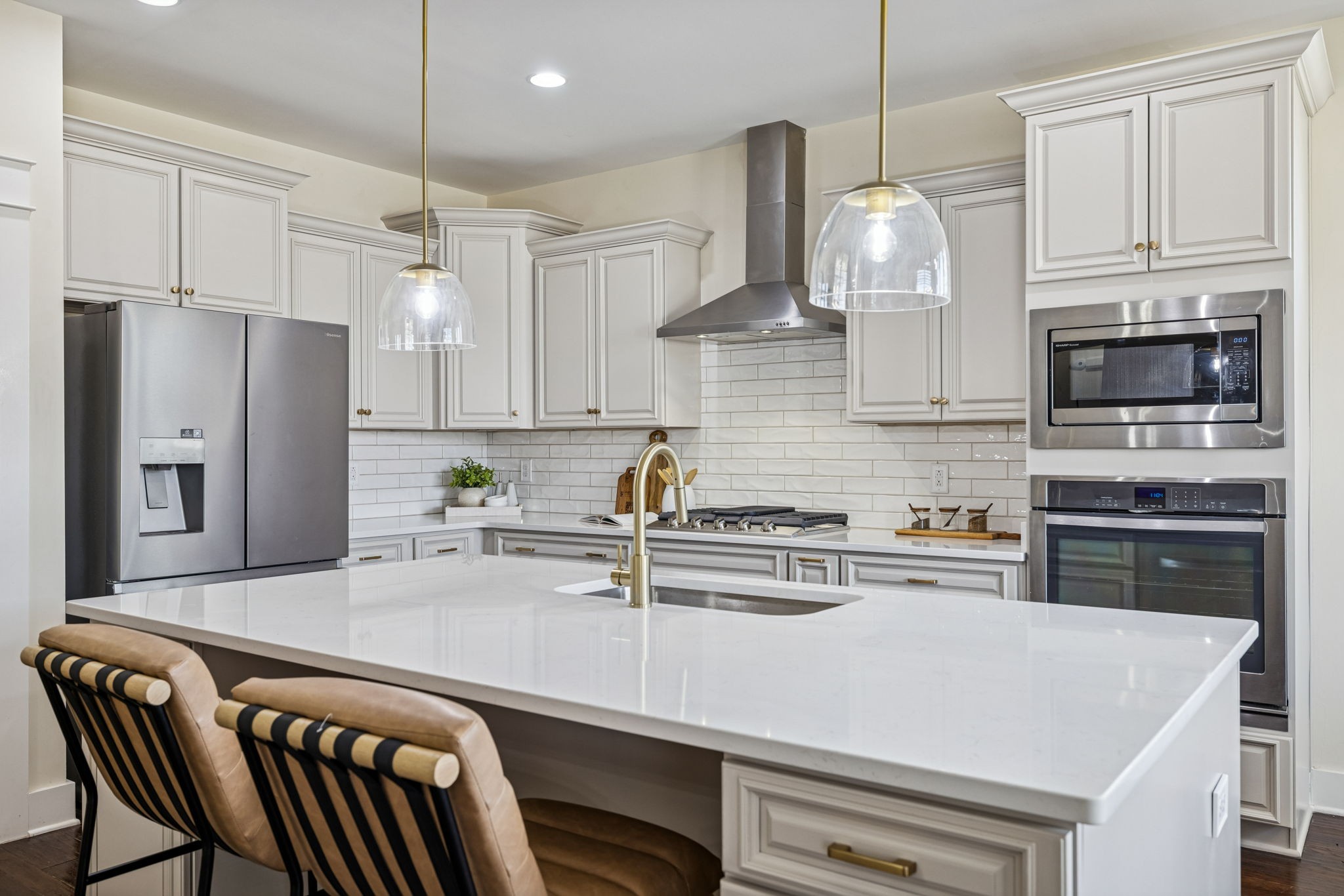 a kitchen with stainless steel appliances a stove a sink a refrigerator a center island and cabinets