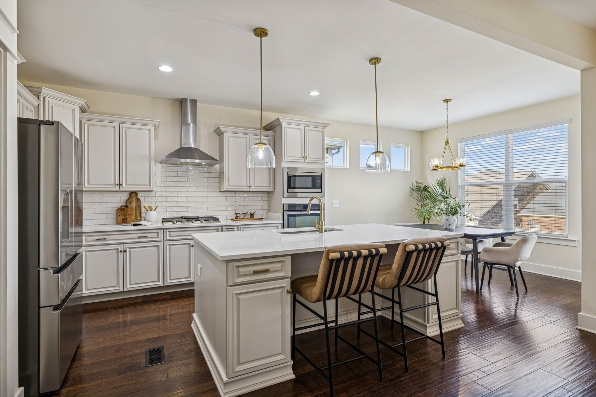 737 Newcomb Street Franklin, TN 37064 - Photo 19 of 99 a kitchen with stainless steel appliances granite countertop a stove a sink a refrigerator a microwave a island with wooden floor and chairs
