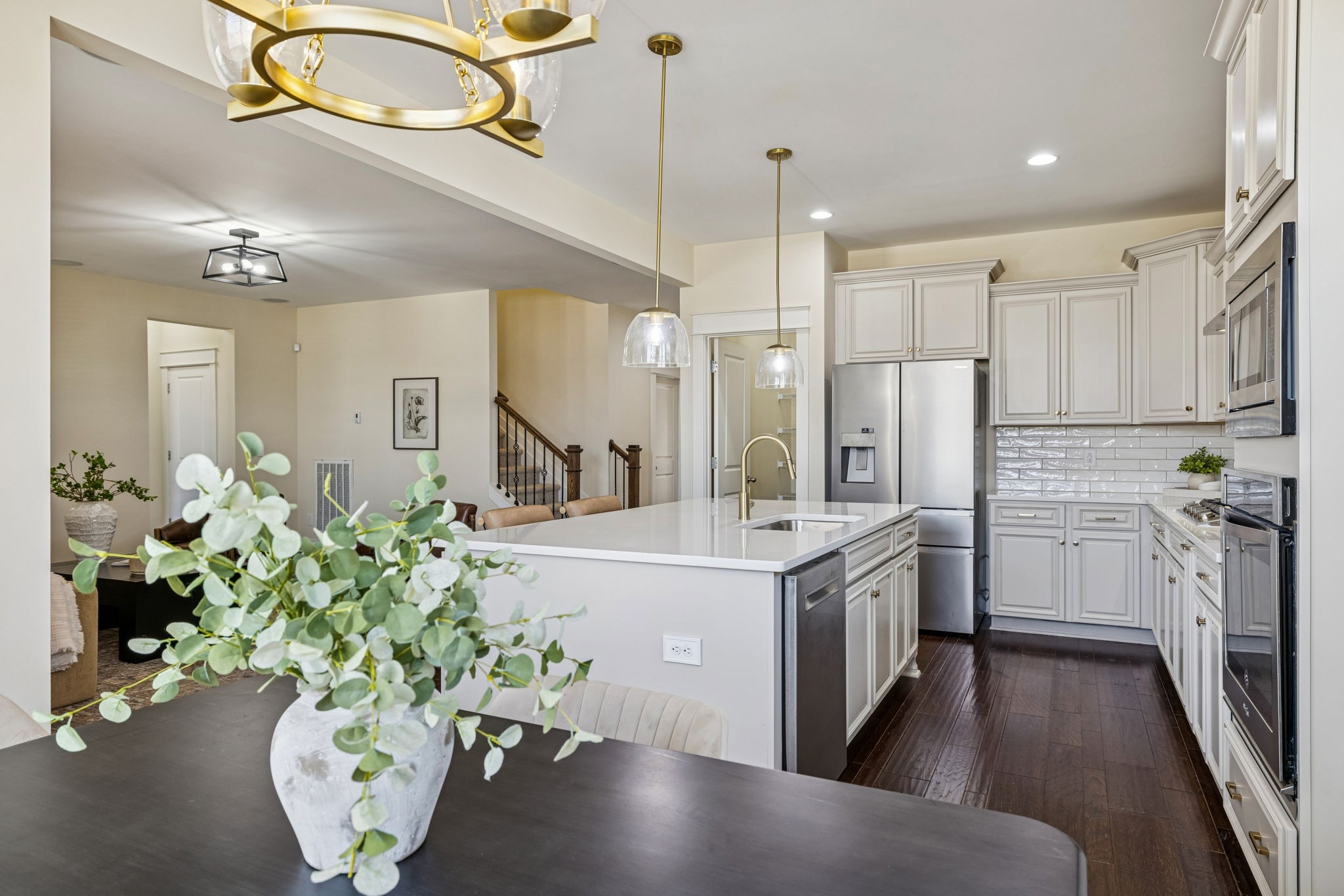 737 Newcomb Street Franklin, TN 37064 - Photo 35 of 99 a kitchen with stainless steel appliances a white refrigerator a sink dishwasher a stove a dining table and chairs with wooden floor