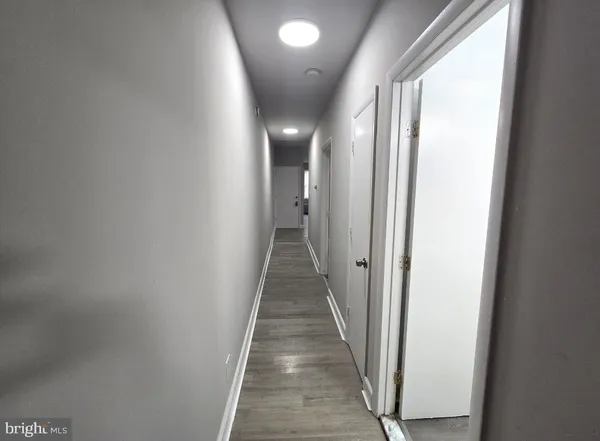 a view of a hallway with wooden floor