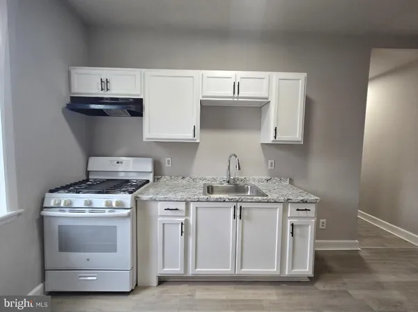 a kitchen with stainless steel appliances a sink a stove and cabinets