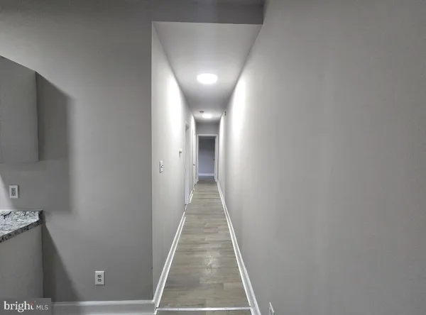 a view of a hallway with wooden floor