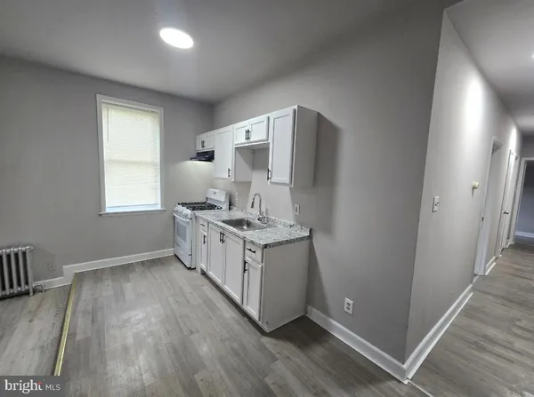 a kitchen with a sink cabinets and wooden floor