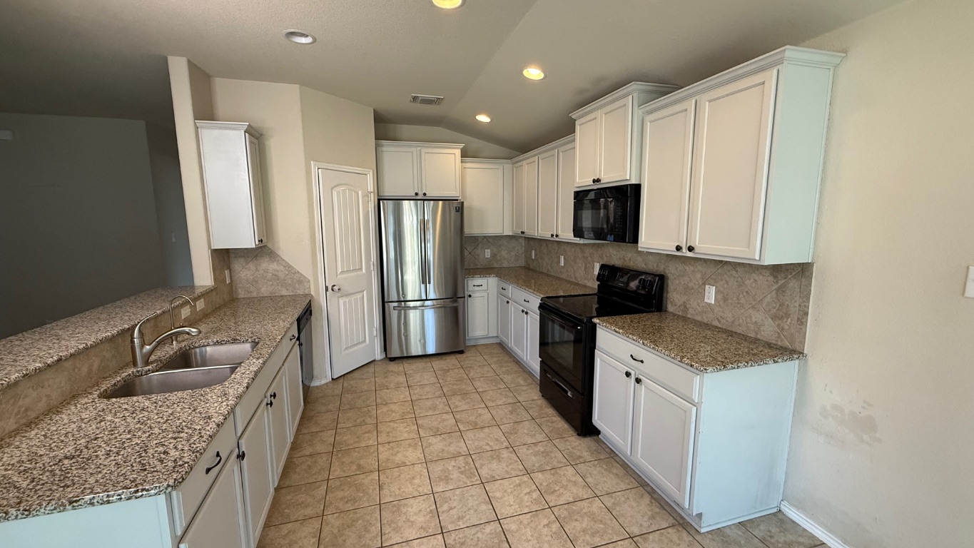 116 Zoisite Lane Jarrell, TX 76537 - Photo 3 of 21 a kitchen with a sink stove and refrigerator