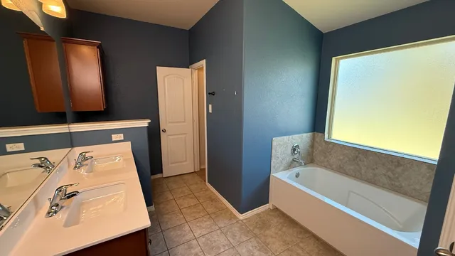 a bathroom with a tub sink and mirror