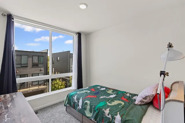 a bedroom with a bed and a large window