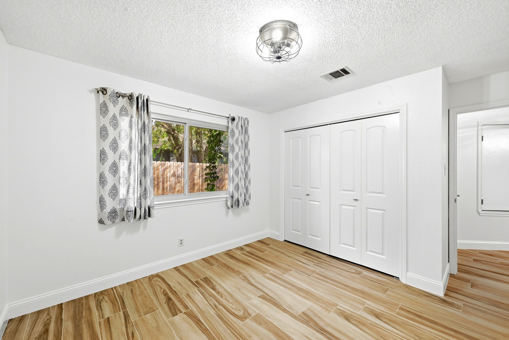 11218 Stormy Ridge Road Austin, TX 78739 - Photo 23 of 38 Gleaming wood-look tile floors anchor this comfortable bedroom featuring a double-door closet.