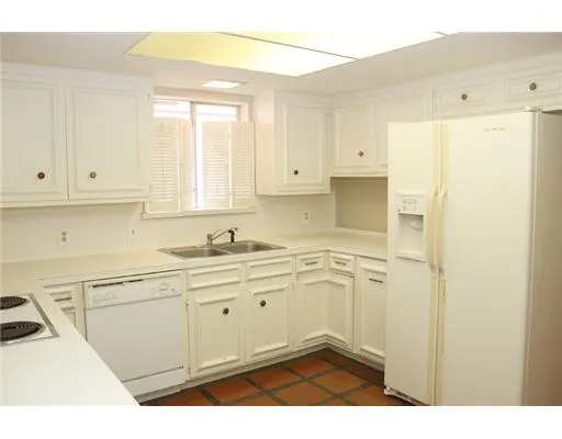 a kitchen with stainless steel appliances granite countertop white cabinets and a refrigerator