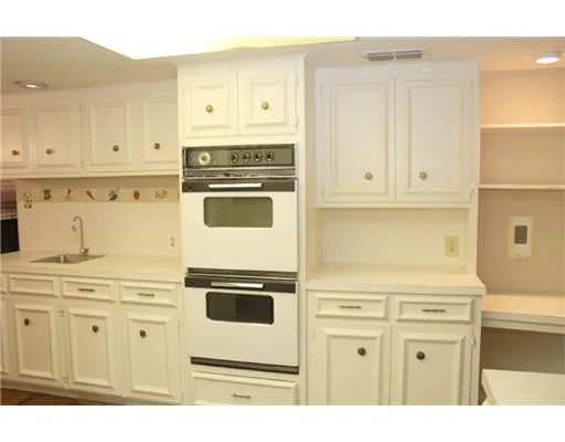 a white kitchen with granite countertop stainless steel appliances