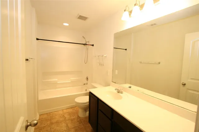 a bathroom with a granite countertop sink a toilet and shower