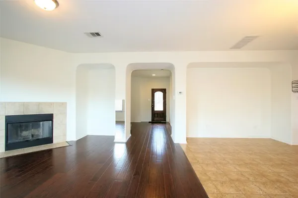 a view of a hallway with wooden floor and a fireplace