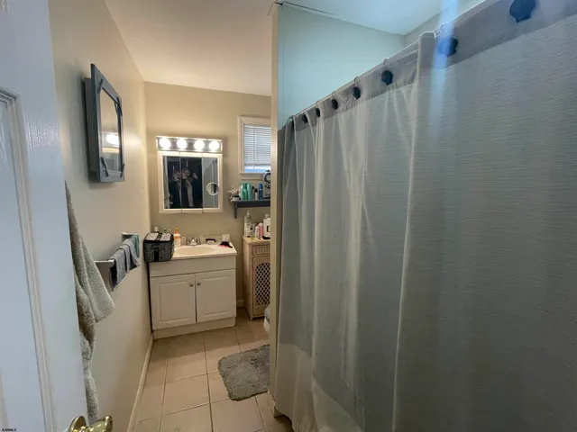 a bathroom with sink a mirror a bathtub and shower